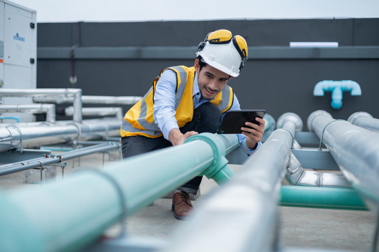 man inspecting pipes